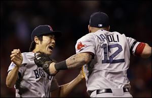 Boston's Koji Uehara and Mike Napoli celebrate after the Red Sox beat the Cardinals 4-2 in Game 4 of World Series on Sunday in St. Louis. The Red Sox tied the series at 2-2.