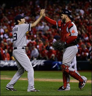 Boston Red Sox relief pitcher Koji Uehara celebrates with David Ross after St. Louis Cardinals left fielder Matt Holliday flied out to right field to end Game 5.