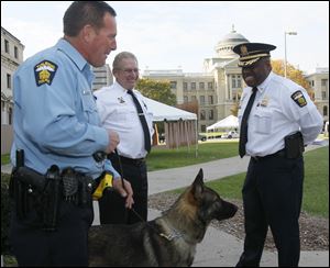 Toledo police Officer Joseph Taylor, left, introduces his furry teammate Joker, 17 months old, to Deputy chief Don Kenney, center, and Chief Derrick Diggs, right.