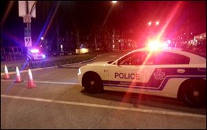 A Montreal police car blocks off a street in a residential area near Trudeau International Airport after the discovery of a potential explosive device found in the carry-on luggage of a 71-year-old man who was headed to Los Angeles.