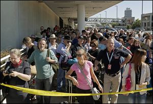 Evacuated passengers wait outside Los Angeles International Airport, where flights were halted.