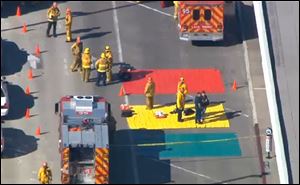 In this aerial video frame grab provided by CBS-LA, fire and rescue personnel gather at Los Angeles International Airport.