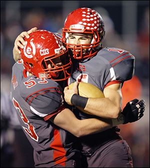 Bedford High School players Dillon Folk (53) and Alec Hullibarger (11) celebrate Hullibarger's  touchdown.