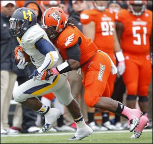 Toledo freshman Kareem Hunt tries to escape the grasp of Bowling Green State University’s D.J. Lynch during a game last week. Hunt has run for 241 yards and three scores the past two games against Navy and BG.