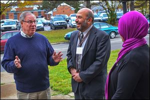 D. Michael Collins, left, talks with Ziad Hummos, center, board member of the Al-Madinah Community Center, and Maria Azzouni, the center's vice president. Mr. Collins spent much of the final Saturday before the election making campaign stops, but his door-to-door efforts were curtailed by the weather.  