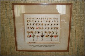 A framed display of some of the more popular fly patterns used to catch trout from Cold Creek hangs in the formal dining room of the farmhouse.