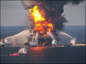 U.S. Coast Guard crews spray water on BP’s Deepwater Horizon offshore oil rig in 2010. The blast killed 11 people and spurred a massive oil spill in the Gulf. 