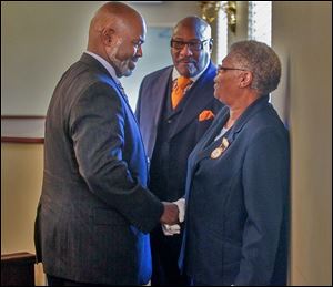 Mayor Mike Bell, left, and Calvin Lawshe, city economic development commissioner, say good-bye to Lillie Winston, chief usher, after services at Jerusalem Missionary Baptist Church.