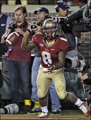 Florida State running back James Wilder, Jr., celebrates after scoring a touchdown against Miami on Saturday night in Tallahassee. Florida State is back in second place in the BCS standings, edging past Oregon behind first-place Alabama.