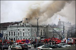 Fire fighters work at the site of a fire today at the building of the School of Modern Drama theater in Moscow.