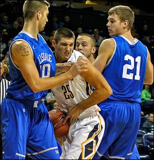 Toledo's Jordan Lauf, a Napoleon graduate, powers through Hillsdale's Tony Nelson, left, and Lucas Grose during an exhibition game at Savage Arena.