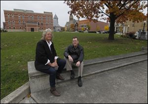 Lisa Swickard and John Huss sit on the steps of what used to be the Seneca County Courthouse in Tiffin. The amateur photographers are raising funds to pay for the publication of their book about the destruction of the courthouse.