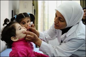A health worker administers polio vaccine to a child as part of a UNICEF-supported vaccination campaign at the Abou Dhar Al Ghifari Primary Health Care Center in Damascus, Syria, in October.
