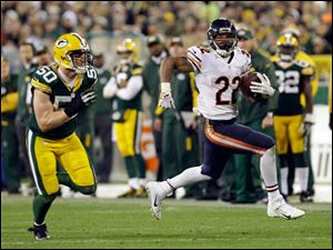 Chicago Bears' Matt Forte runs past Green Bay Packers' A.J. Hawk (50) during the second half.