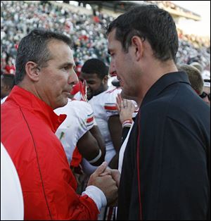 Luke Fickell, right, talks with Ohio State head coach Urban Meyer during a recent game. 