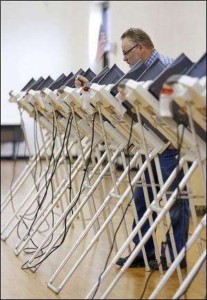 Dave Fitzpatrick looks over his choices as he casts his vote at Garfield Elementary in East Toledo. Only a quarter of Lucas County’s registered voters turned out Tuesday.
