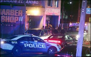 Police gather at a scene of a multiple shooting at Al's Place Barber Shop, Wednesday, in Detroit.