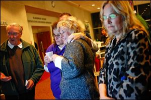 TPS spokesperson Patty Mazur, left, hugs board member Lisa Sobecki as they watch results along with Sylvania resident Stan Odesky and board candidate Polly Taylor-Gerken.
