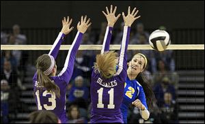 St. Ursula's Lauren Daudelin, right, hits the ball past Columbus DeSales players Kendall Witt, left, and Emily Durbin. Daudelin finished with 10 kills.