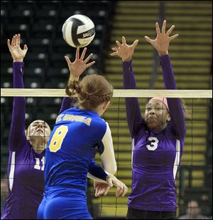 St. Ursula’s Lauran Graves, center, hits the match winner past Columbus DeSales defenders Emily Durbin, left, and Kenya Cason during a Division I state semifinal. St. Ursula (29-0) won 3-0.