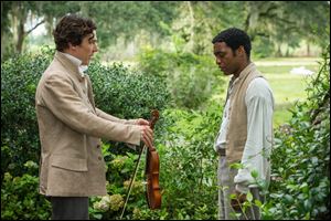 This image released by Fox Searchlight shows Benedict Cumberbatch, left, and Chiwetel Ejiofor in a scene from 