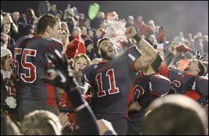 Bedford High School players, including Cole Hoffman (55) and Alec Hullibarger (11) celebrate their win with their fans Friday night in Temperance, Mich.
