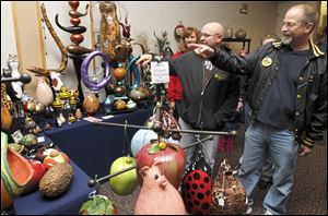 Maumee residents, from left, Jennifer Coe, Chuck Coe, and Bob Ducat are amused by the decorated gourds at the Toledo Craftsman’s Guild arts and crafts show at the Stranahan Great Hall in Toledo.
