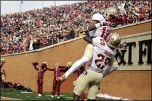 Florida State defensive back Jalen Ramsey, top, jumps into the arms of teammate Nate Andrews after Andrews ran back an interception for a touchdown against Wake Forest on Saturday in Winston-Salem, N.C.