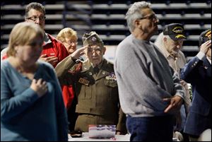 World War II veteran Guadalupe Flores, center, salutes as 'Taps' is played at the conclusion of the ceremony. 