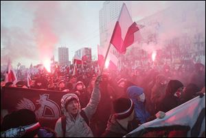 People hold burning flares as they march through  downtown Warsaw  to mark the 95th anniversary of Poland's Independence Day in Warsaw, Poland, today.