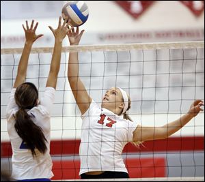 Bedford senior Taylor Purcell, right, hits the ball against  Adrian’s Samantha Regalado.