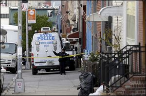A police officer puts up tape near a crime scene in the Brooklyn section of New York, Monday.  A musician shot and killed two members of an Iranian indie rock band and a third musician early Monday, and wounded a fourth person at their apartment before killing himself on the roof, police and the group's manager said.