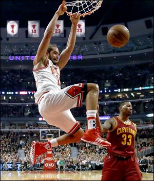 Chicago Bulls center Joakim Noah (13) dunks the ball past Cleveland Cavaliers small forward Alonzo Gee (33) during the first half of an NBA basketball game Monday, Nov. 11, 2013, in Chicago. (AP Photo/Charles Rex Arbogast)