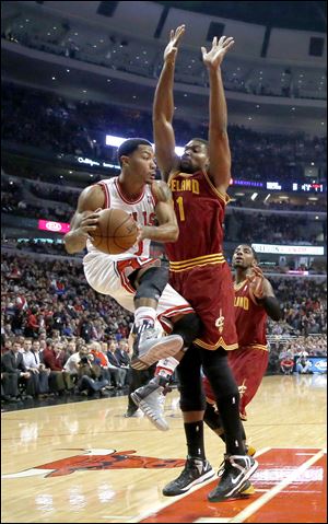 Chicago Bulls point guard Derrick Rose (1) looks to pass the ball past Cleveland Cavaliers center Andrew Bynum during the first half 