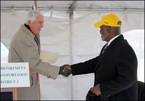 Ohio Department of Transportation Director Jerry Wray, left, shakes hands with Toledo Mayor Mike Bell during a ribbon cutting ceremony at the ProMedica Parkway Bridge over I-475.