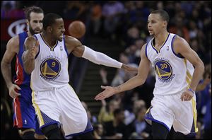 Golden State Warriors' Andre Iguodala (9) and Stephen Curry, right, celebrate a score by Curry.