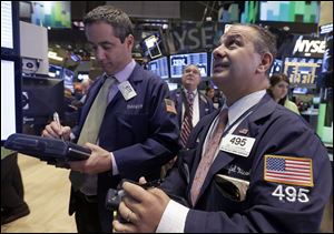 Trader Daniel Trimble, left, and Joseph Lucchese, right, work on the floor of the New York Stock Exchange today.