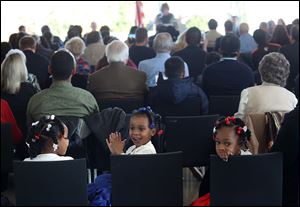 Miyonnah Gordon, 5, left, and her sisters Serinity, 3, and Mariah, 5, sit together during the naturalization ceremony. The girls’ mother, Kymaeh Brisbane Gordon of Liberia, took her oath.