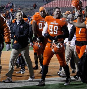 BGSU head football coach Dave Clawson exits the field with his team after defeating Ohio University.
