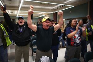 Boeing machinists react as the results of a vote are read at the International Association of Machinists union hall in Seattle. Boeing machinists in the Northwest rejected a contentious contract proposal Wednesday that would have exchanged concessions for decades of secure jobs. 
