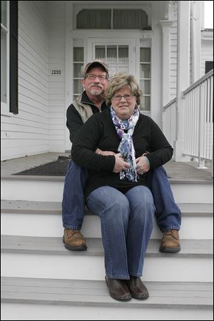 Bill and Leslie Nestor of Marblehead, Ohio, sit on the steps of the property they got for a bid of $710,000. They said they plan to move in to Castalia Farms.