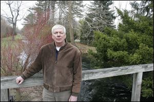 Doug Entenman of Fostoria bought part of Castalia Farms with a $620,000 bid. He’s on a wooden bridge over Cold Creek, a pristine waterway filled with trout.