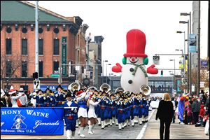 Members of tjhe Anthony Wayne High School band are followed by a huge balloon of Frosty the Snowman. The parade, a downtown Toledo tradition, offered several floats for spectators to enjoy.