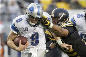 Detroit Lions quarterback Matthew Stafford scrambles for a first down as Pittsburgh Steelers defensive end Cameron Heyward pursues Sunday in Pittsburgh.