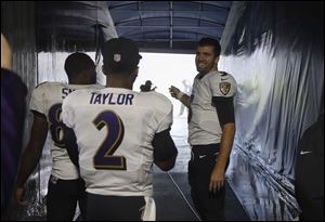 Baltimore Ravens quarterback Joe Flacco watches the severe storm passing through the area from inside the tunnel with Torrey Smith and Tyrod Taylor during their game against the Bears on Sunday in Chicago. Play was suspended for about two hours.