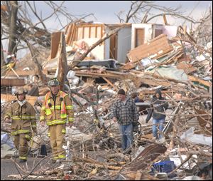 Firefighters survey the destruction on a street in Washington, Ill., after a tornado unleashed its fury Sunday. Homes and buildings were destroyed in seconds by the swift-moving storm.