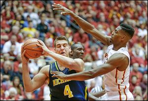 Michigan forward Mitch McGary, left, looks to pass around Iowa State forward Melvin Ejim during the second half in Ames, Iowa.