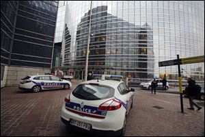 Police cars park near the entrance of the Societe General Bank headquarters in La Defense business district, west of Paris, today. Soon after a shooting at newspaper Liberation, shots were fired at the headquarters of the French bank.