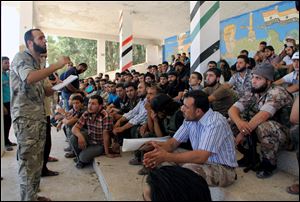 Abdul-Qadir Saleh, left, the chief commander of the Tawhid Brigade, the main rebel outfit in Aleppo province, speaks to his fighters ahead of an attack on government troops, in Aleppo, Syria, in August.
