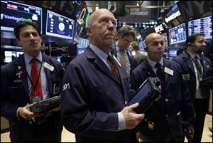 Traders work on the floor of the New York Stock Exchange today. The Dow Jones industrial average crossed 16,000 points for the first time early Monday and the Standard & Poor's 500 index crossed 1,800 points.